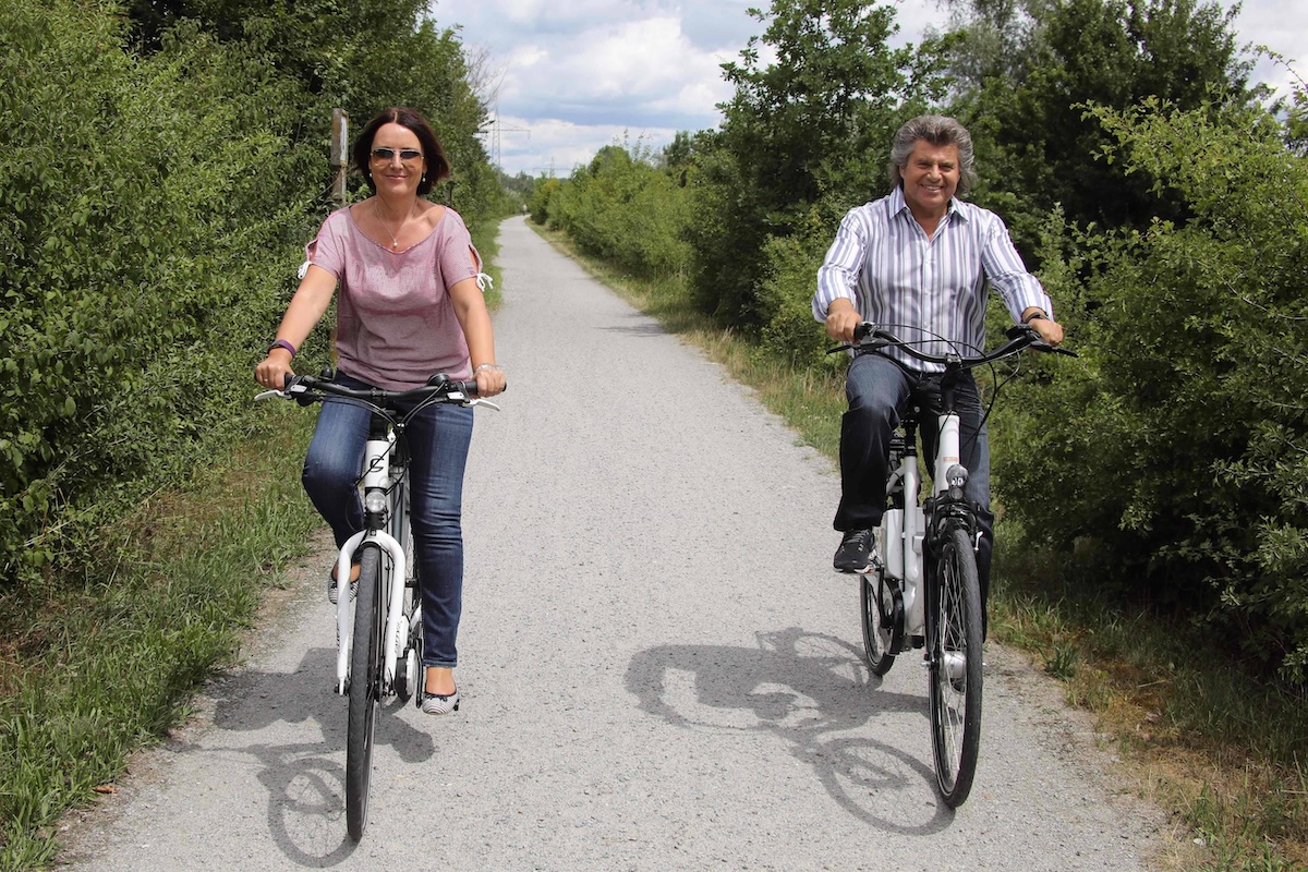 Am Rande von Fimaufnahmen zum Thermen OpenAir ist Andy Borg zu Fuss und mt dem Fahrrad unterwegs Andy Borg und Ehefrau Birgit / Am Rande von Fimaufnahmen zum Thermen OpenAir ist Andy Borg zu Fuss und mt dem Fahrrad unterwegs, Kurpark, Innufer, Bad Fuessing, 20170711 at Edge from to Therms Openair is Andy Borg to Foot and Mt the Bicycle on the road Andy Borg and Wife Birgit at Edge from to Therms Openair is Andy Borg to Foot and Mt the Bicycle on the road Park Innufer Bath Fuessing